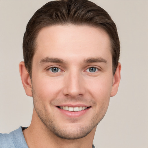 Joyful white young-adult male with short  brown hair and grey eyes