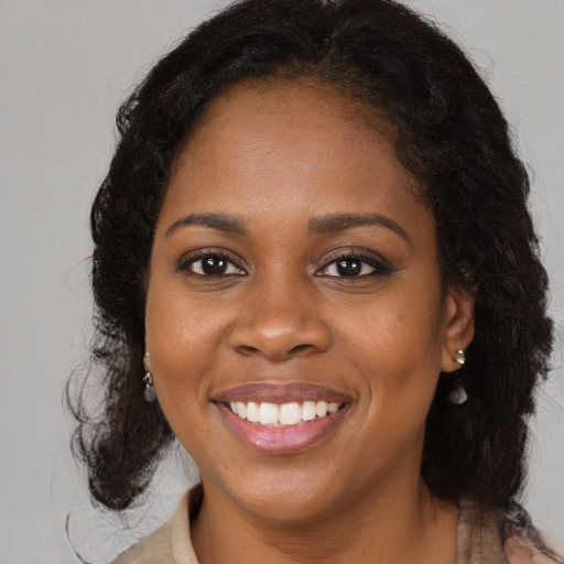 Joyful black young-adult female with medium  brown hair and brown eyes