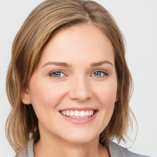 Joyful white young-adult female with medium  brown hair and blue eyes