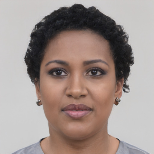 Joyful black young-adult female with short  black hair and brown eyes