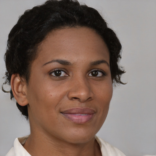 Joyful black young-adult female with short  brown hair and brown eyes
