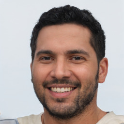 Joyful latino young-adult male with short  black hair and brown eyes