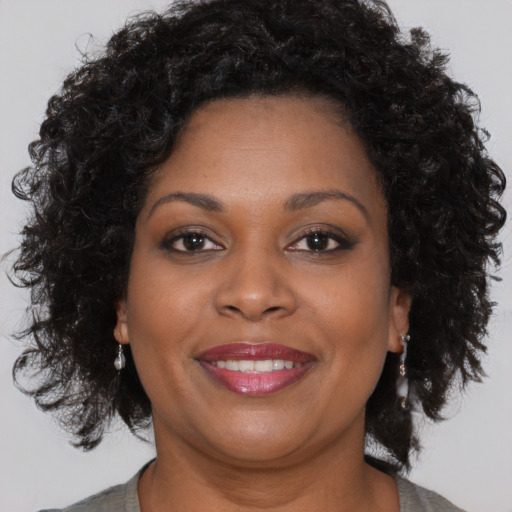 Joyful black adult female with long  brown hair and brown eyes
