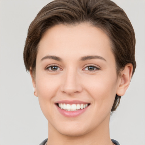 Joyful white young-adult female with short  brown hair and grey eyes