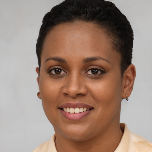 Joyful black young-adult female with short  brown hair and brown eyes