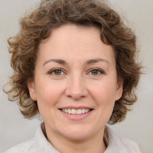 Joyful white adult female with medium  brown hair and green eyes