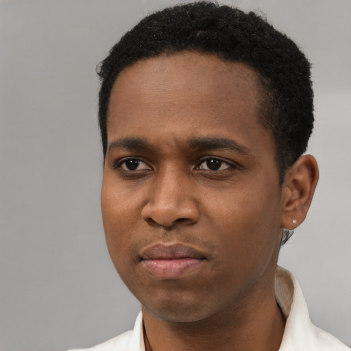 Joyful black young-adult male with short  black hair and brown eyes