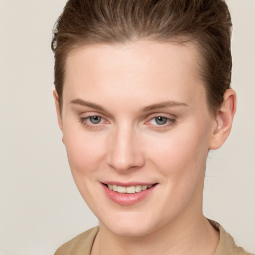 Joyful white young-adult female with short  brown hair and grey eyes