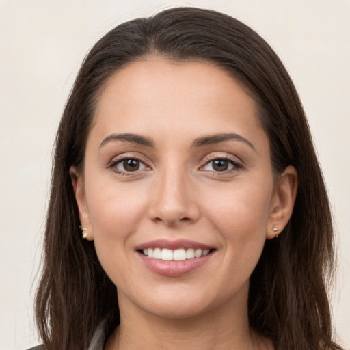 Joyful white young-adult female with long  brown hair and brown eyes