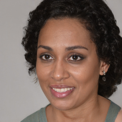Joyful black adult female with medium  brown hair and brown eyes