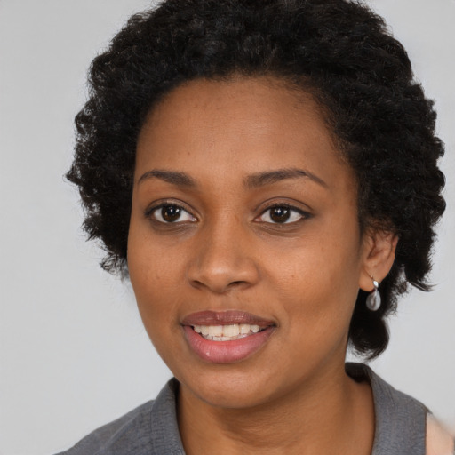 Joyful black young-adult female with medium  black hair and brown eyes