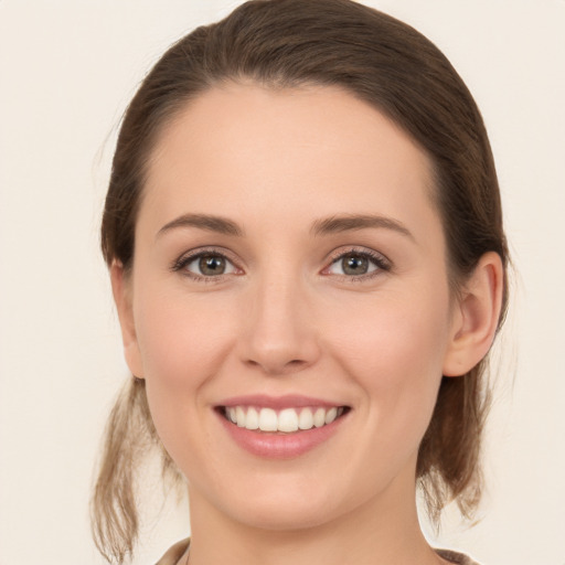 Joyful white young-adult female with medium  brown hair and grey eyes