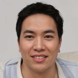 Joyful asian young-adult male with short  brown hair and brown eyes