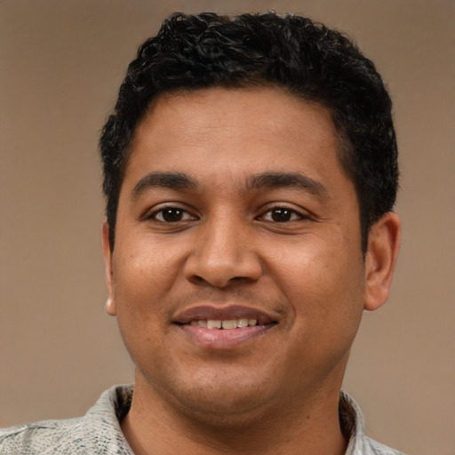Joyful latino young-adult male with short  black hair and brown eyes