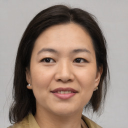 Joyful asian young-adult female with medium  brown hair and brown eyes