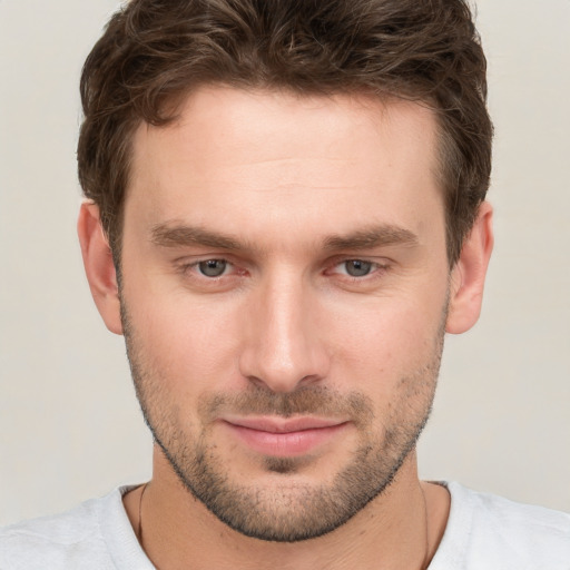 Joyful white young-adult male with short  brown hair and grey eyes