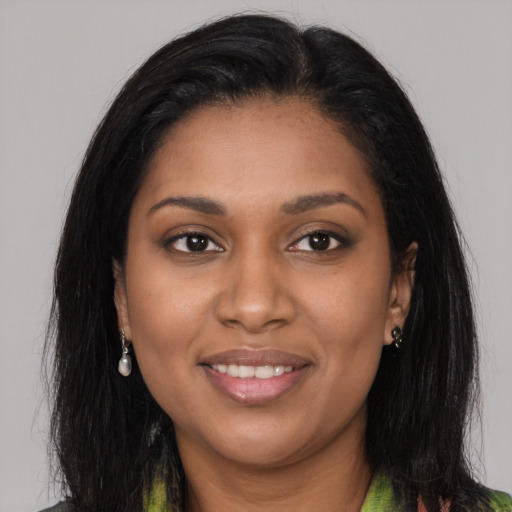 Joyful black young-adult female with long  brown hair and brown eyes