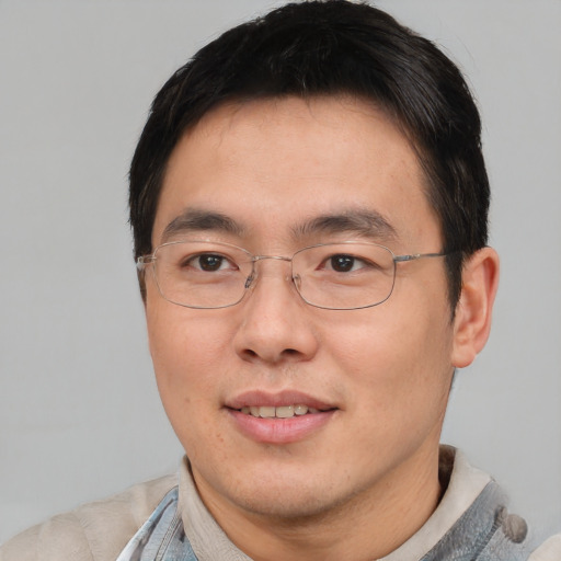 Joyful asian adult male with short  brown hair and brown eyes
