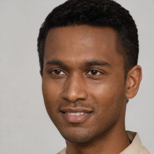 Joyful black young-adult male with short  black hair and brown eyes