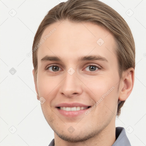 Joyful white young-adult male with short  brown hair and grey eyes