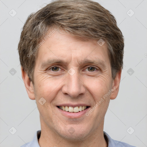 Joyful white adult male with short  brown hair and grey eyes