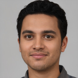 Joyful latino young-adult male with short  black hair and brown eyes