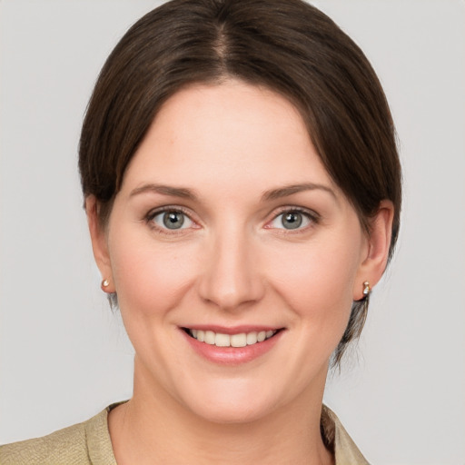 Joyful white young-adult female with medium  brown hair and grey eyes