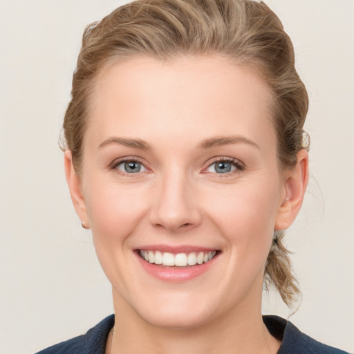 Joyful white young-adult female with medium  brown hair and blue eyes