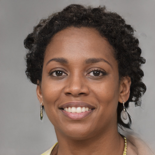 Joyful black young-adult female with short  brown hair and brown eyes