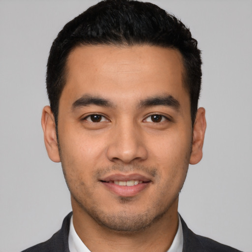 Joyful latino young-adult male with short  black hair and brown eyes