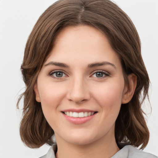 Joyful white young-adult female with medium  brown hair and green eyes