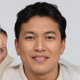 Joyful asian young-adult male with short  brown hair and brown eyes