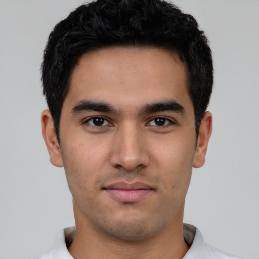 Joyful latino young-adult male with short  black hair and brown eyes