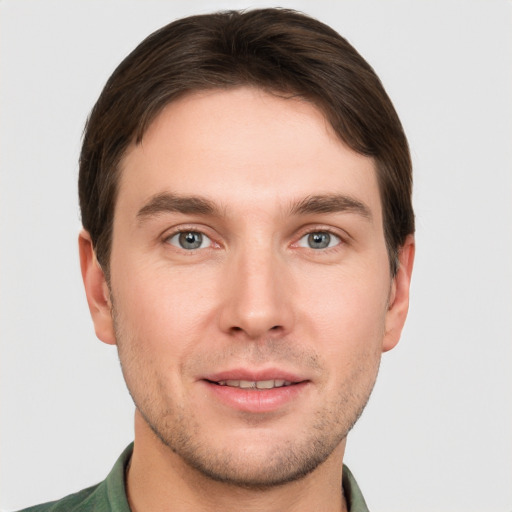 Joyful white young-adult male with short  brown hair and grey eyes