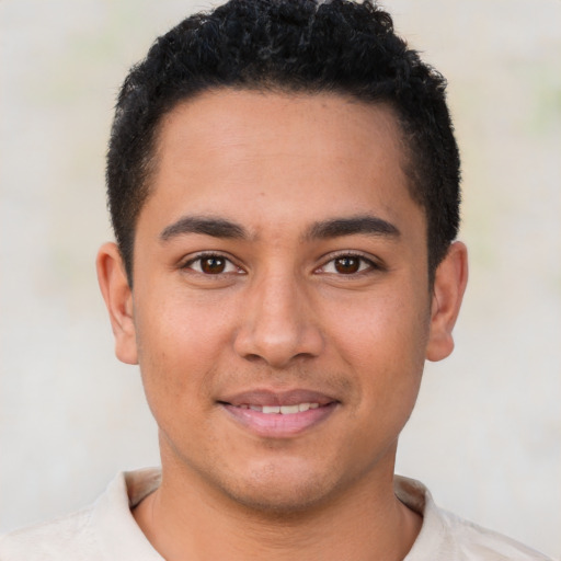 Joyful latino young-adult male with short  brown hair and brown eyes