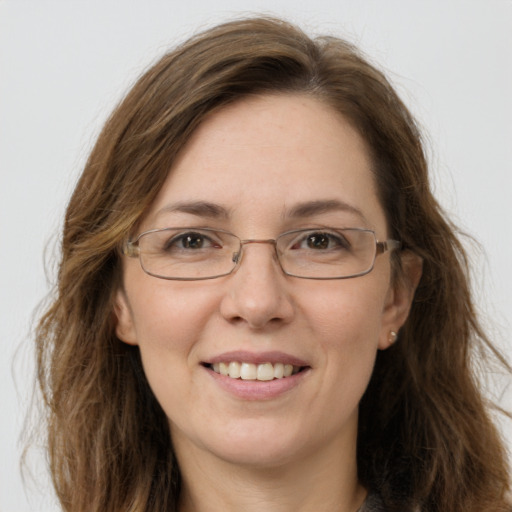 Joyful white adult female with long  brown hair and green eyes