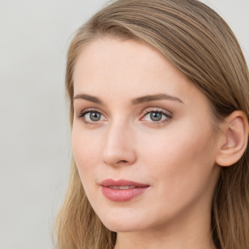 Joyful white young-adult female with long  brown hair and blue eyes