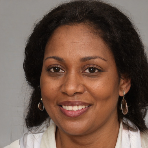 Joyful black adult female with medium  brown hair and brown eyes