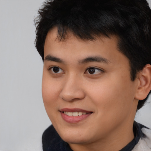 Joyful asian young-adult male with short  brown hair and brown eyes