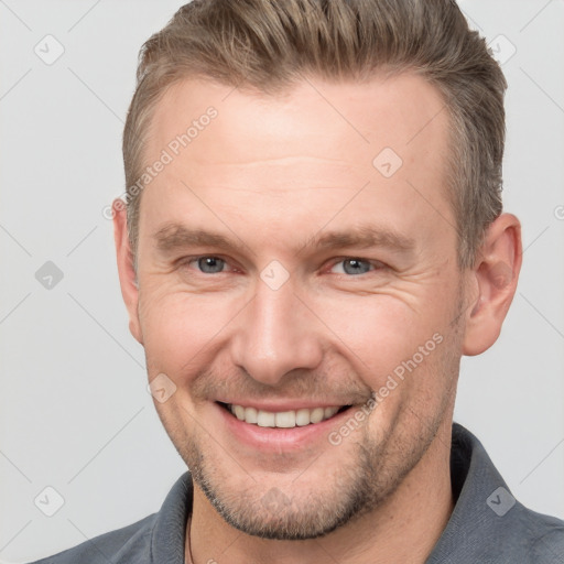 Joyful white adult male with short  brown hair and grey eyes