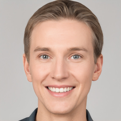 Joyful white young-adult male with short  brown hair and grey eyes