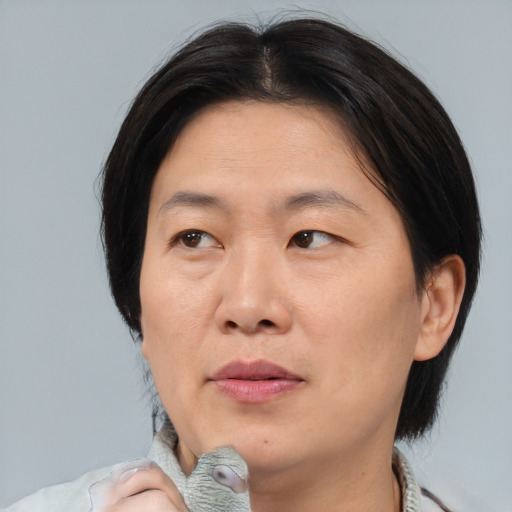 Joyful asian adult female with medium  brown hair and brown eyes