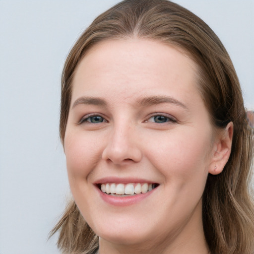 Joyful white young-adult female with long  brown hair and blue eyes