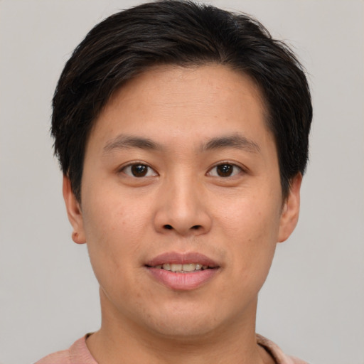 Joyful asian young-adult male with short  brown hair and brown eyes