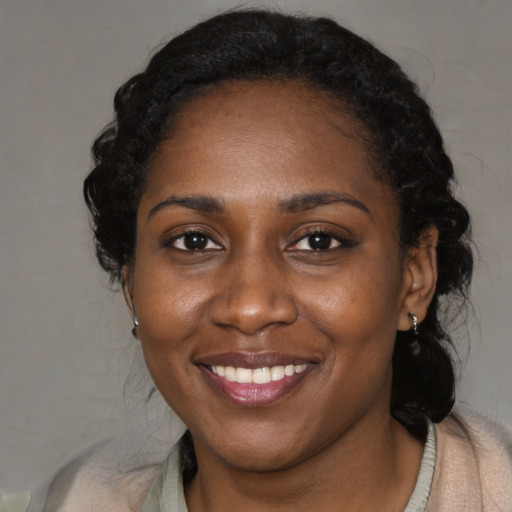 Joyful black adult female with long  black hair and brown eyes