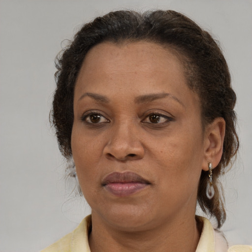 Joyful black adult female with medium  brown hair and brown eyes
