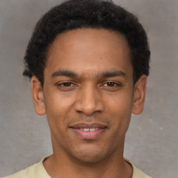 Joyful latino young-adult male with short  brown hair and brown eyes