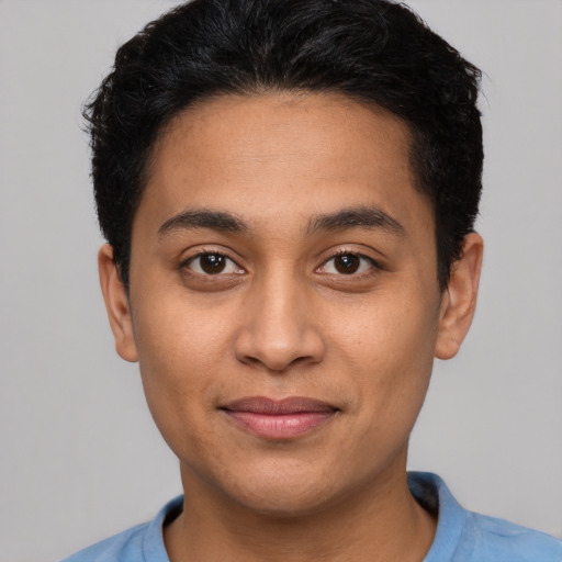 Joyful latino young-adult male with short  brown hair and brown eyes