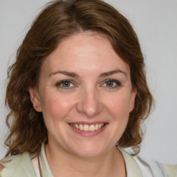 Joyful white young-adult female with medium  brown hair and blue eyes