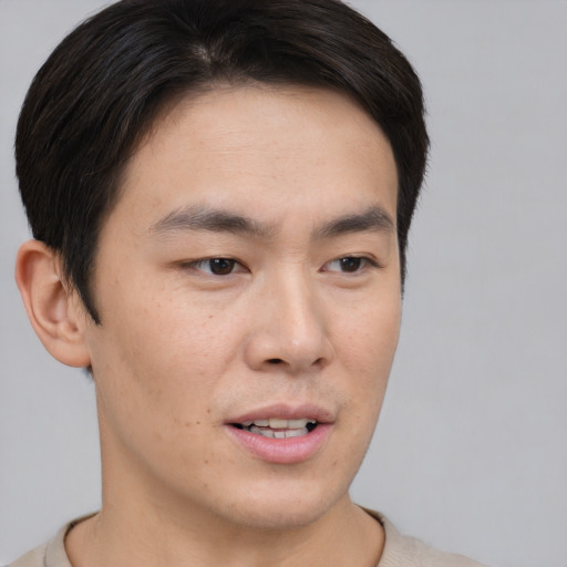Joyful asian young-adult male with short  brown hair and brown eyes